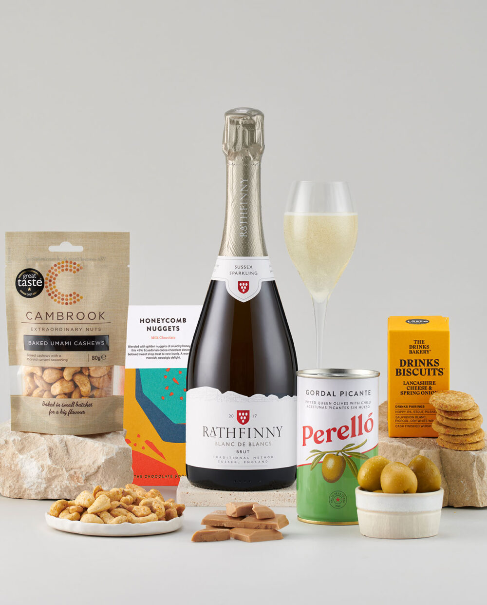 Bottle of Blanc de Blancs 2018 Surrounded by a Selection of Smartly Packaged Foods.