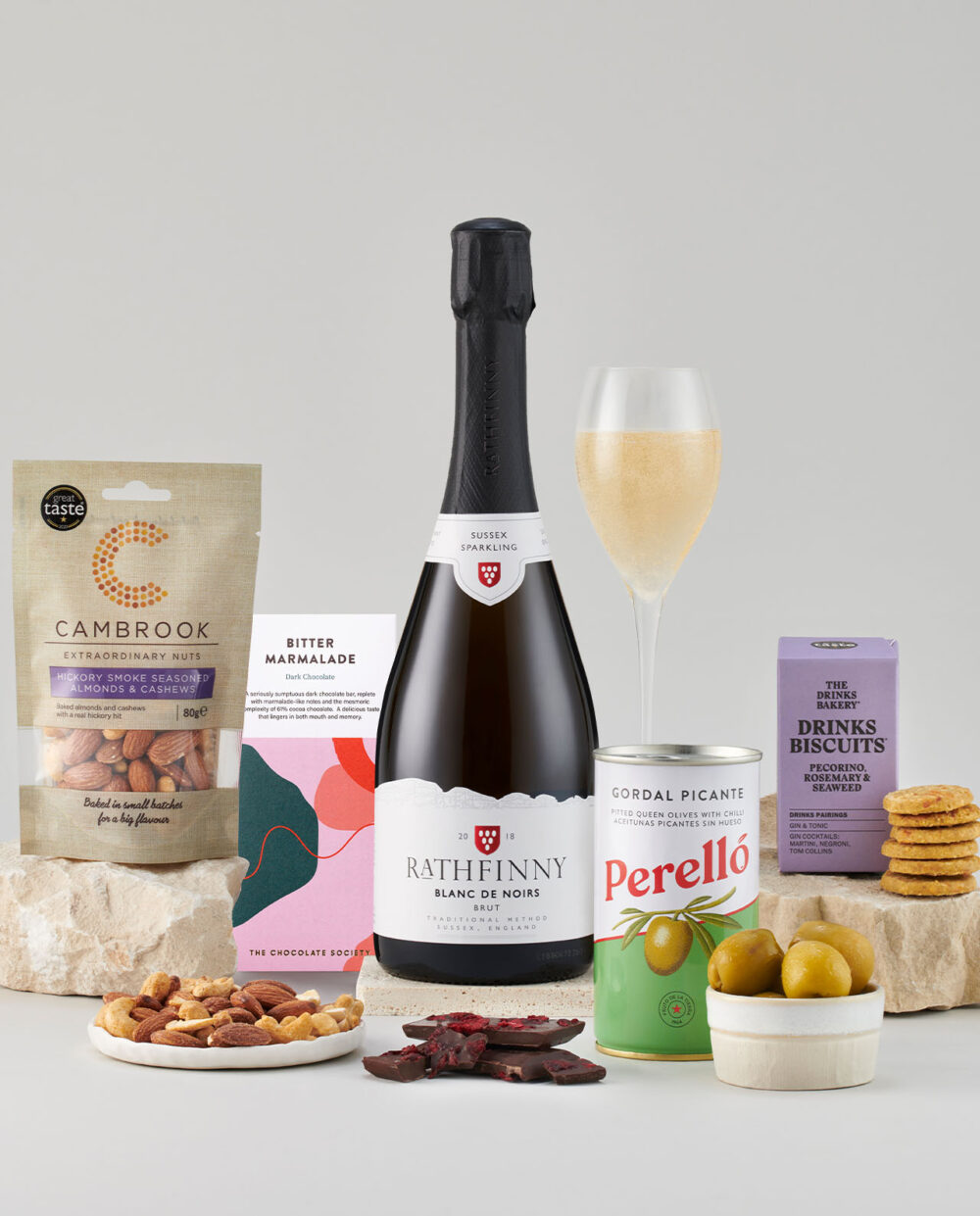 Bottle of Blanc de Noirs 2018 Surrounded by a Selection of Smartly Packaged Foods.
