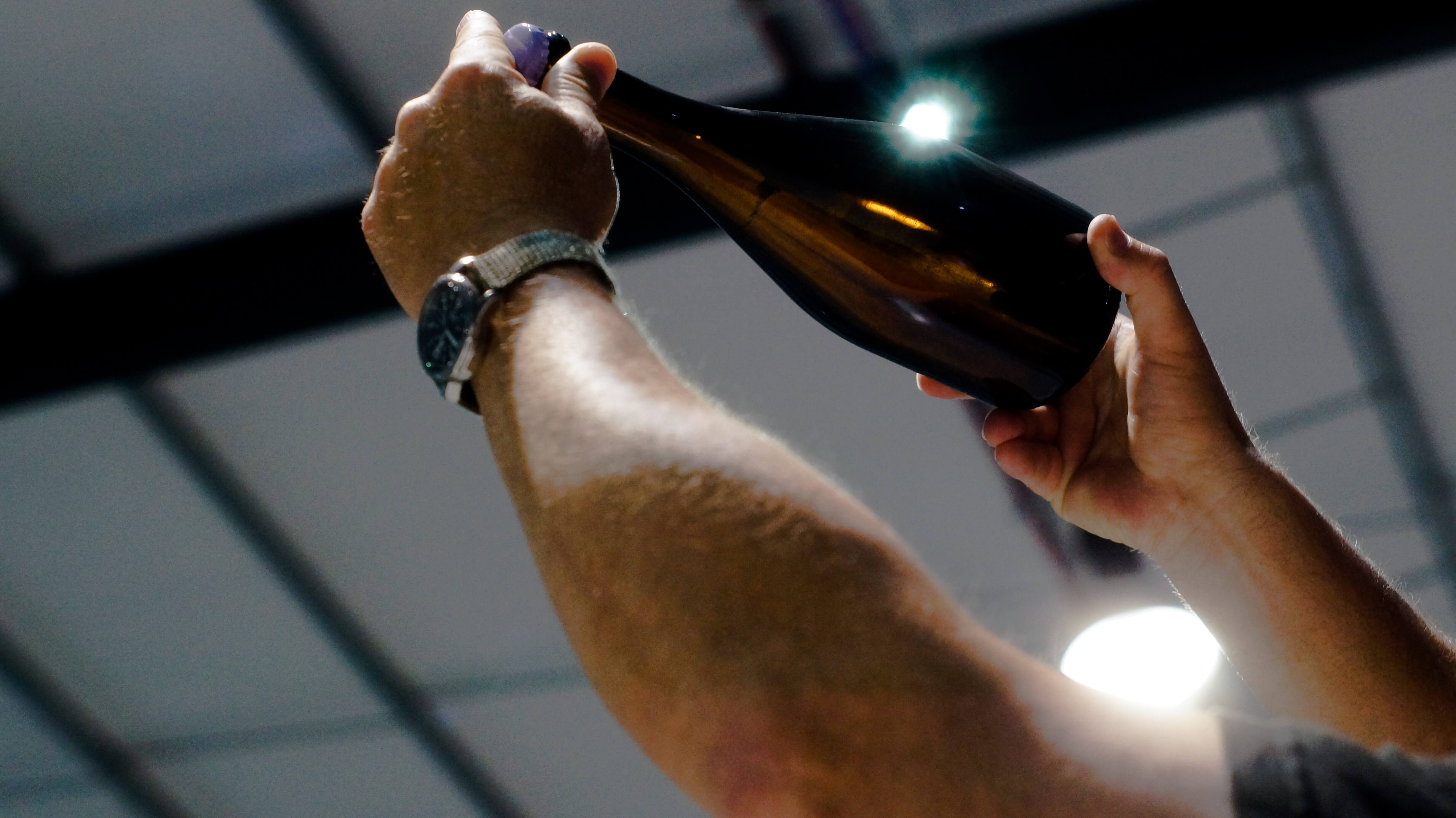 Mark holding a plain Rathfinny Reserved bottle up to the light